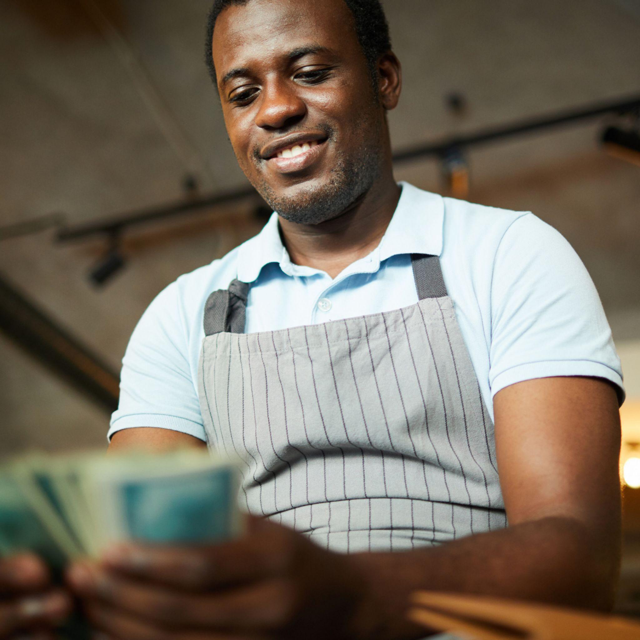 A business man with eyes fixed on the money in his hands.