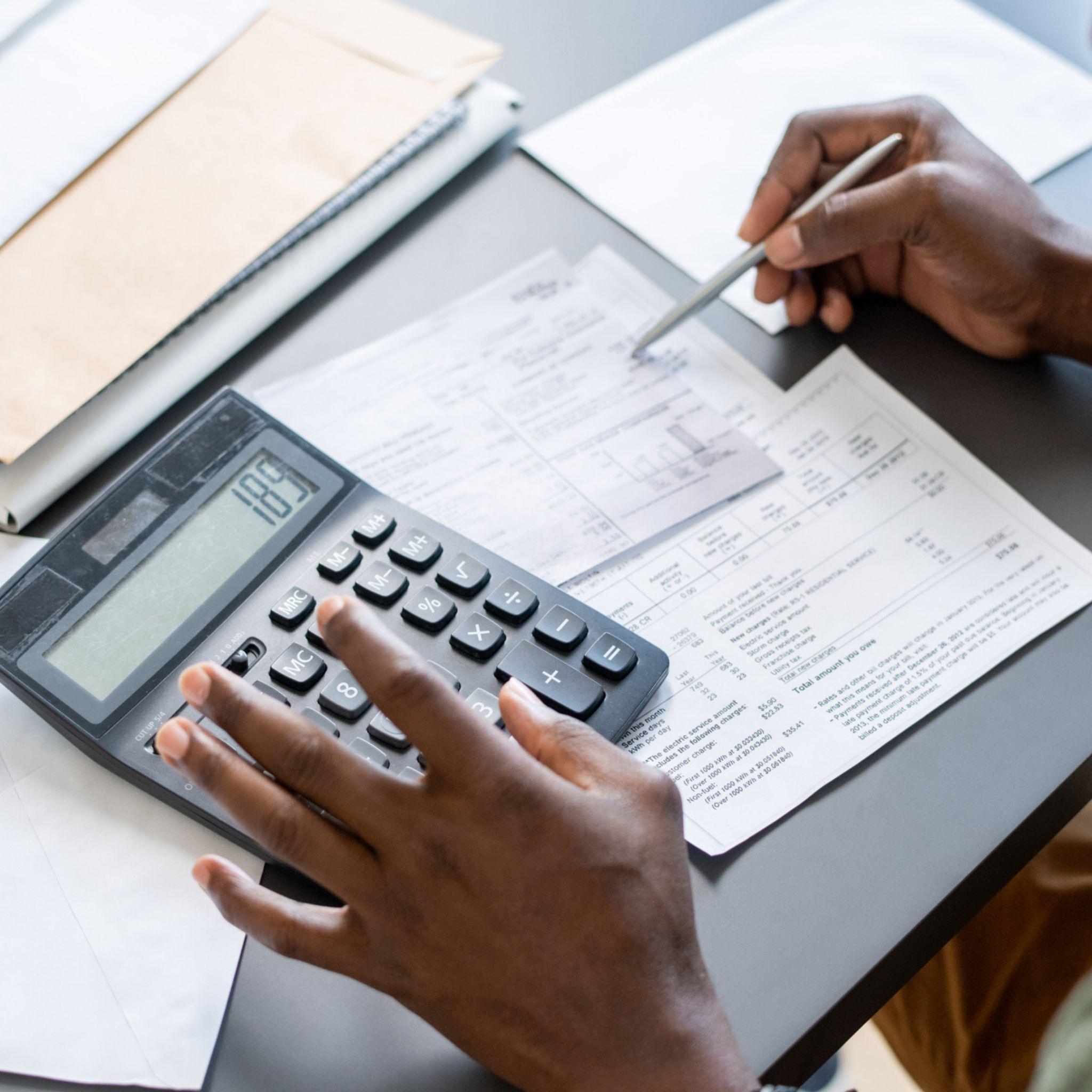 Business owner calculating costs to reduce over spending
